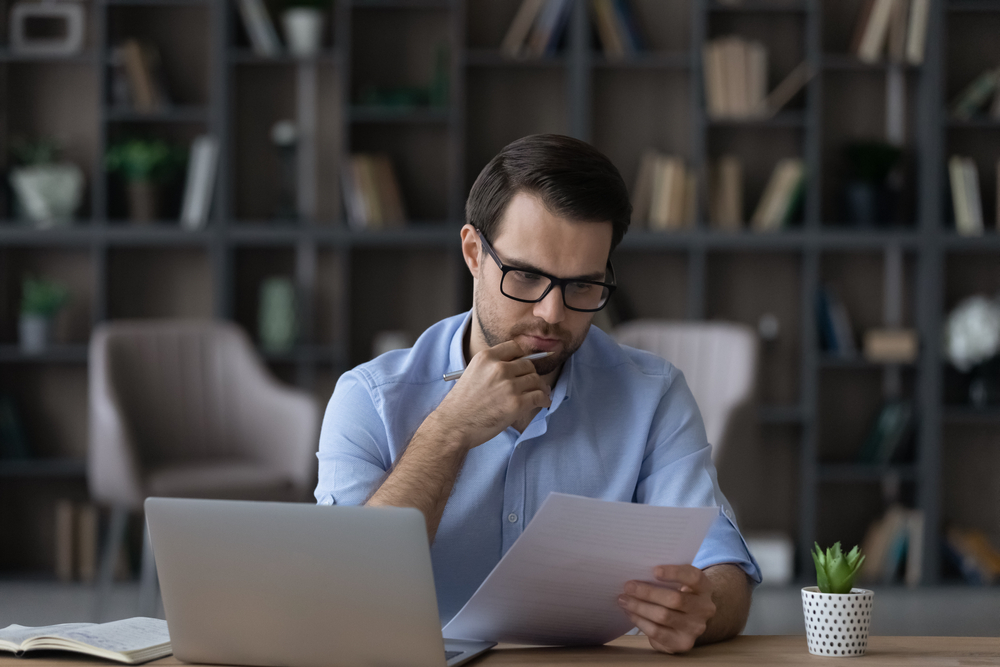 working,with,papers.,serious,millennial,male,entrepreneur,work,at,home